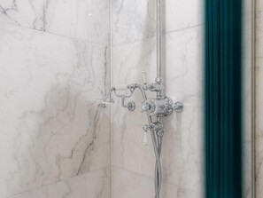 A bathroom with a shower, marble tiles, and a teal curtain. - Five Bedroom Near Camden Arts Centre by Bevilla (London)