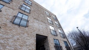 A multi-story brick building with multiple balconies and large windows. - Victoria Park Vista One-bedroom by Sojo Stay (London)