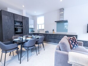 Enjoy a stylish living space with a modern kitchen, dining area, and comfortable seating.