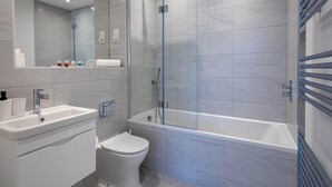 A modern bathroom with a glass-enclosed shower, a white sink, and a toilet. - Horniman Museum Harmony Two-bedroom by Sojo Stay (Mitcham)