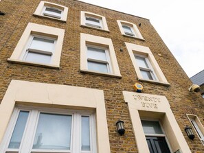 A multi-story brick building with a sign reading "TWENTY FIVE" and "ELV".