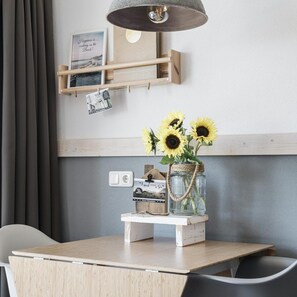 Cozy retreat with a minimalist design, featuring a wooden table, chair, and unique lamp.