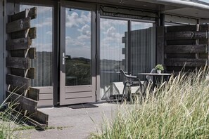 Sit and enjoy the serene surroundings from this outdoor seating area with a table and two chairs.