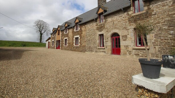 A row of stone buildings with red doors and a gravel driveway. - Spacious 5-bedroom countryside house, pet-friendly, parking, internet included, near Mont St-Michel (Saint-Laurent-de-Terregatte)