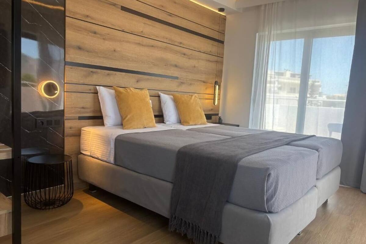 A modern bedroom with a large bed, wooden panel wall, and a view of the city.