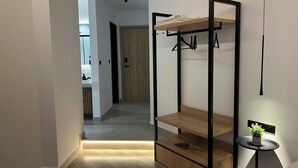 Un interior moderno con una litera, una mesita con una planta y un pasillo que lleva a un baño.