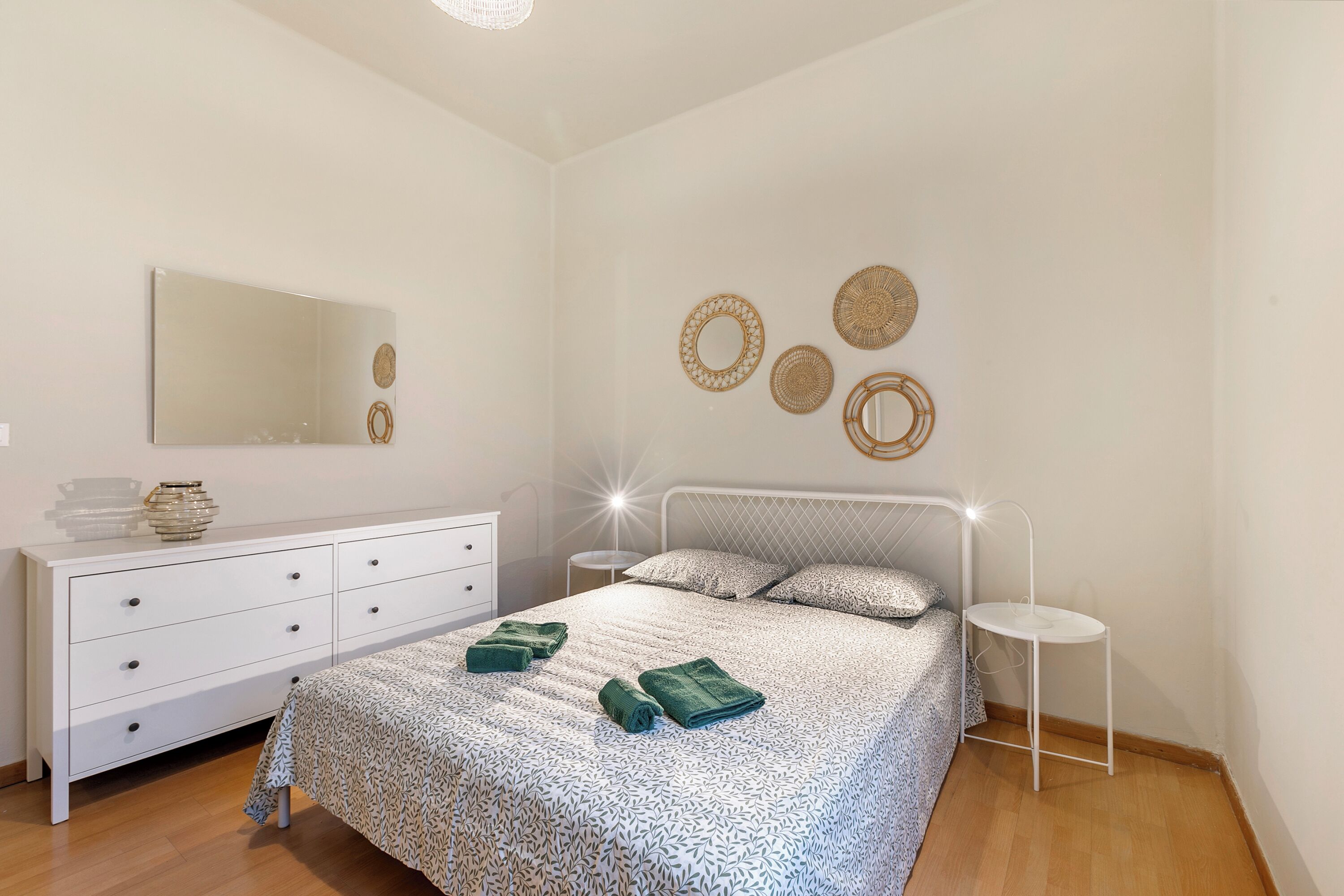 Une chambre à coucher comprenant un lit, une commode, une table de chevet et des éléments de décoration murale.