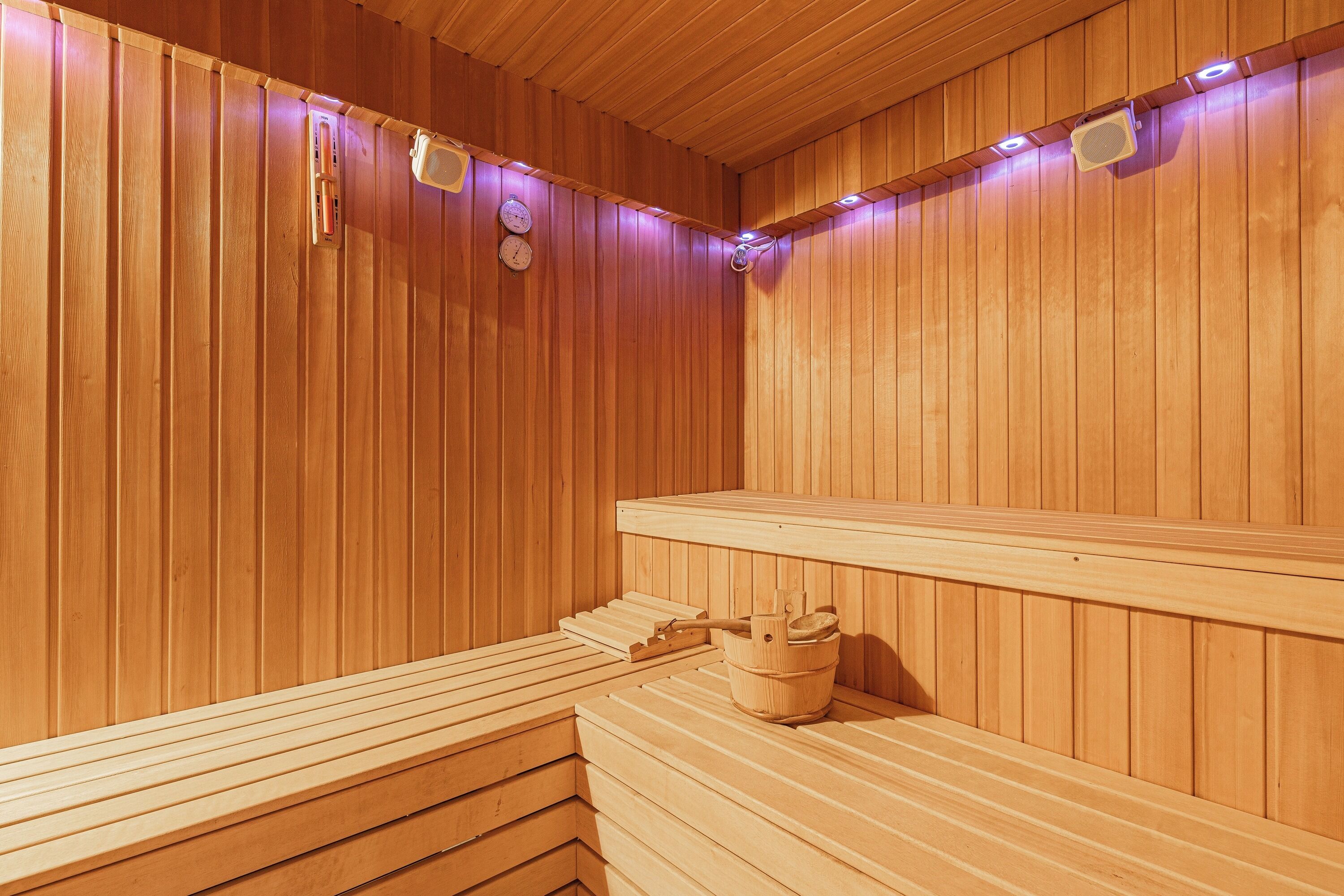 Una sauna de madera con bancos y un cubo.