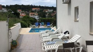 A rooftop terrace with lounge chairs, a pool, and a view of the surrounding neighborhood. - S&A Apartment (Sutivan)