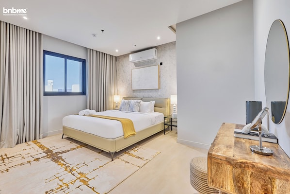 Relax in a serene space with a large bed, nightstand, and window with curtains.