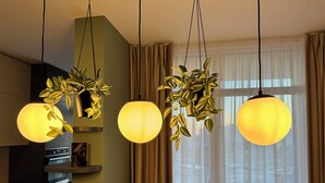 A modern kitchen with pendant lights, a built-in oven, and a small dining area with a table and chairs. - Joy City Stay Nord One N2-49 (Timișoara)