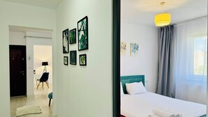 Habitación de hotel con cama, escritorio y silla. En la pared, hay cuadros enmarcados.
