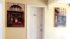 A hallway with a wooden herringbone floor, a white door labeled "PRIVATE," and two framed pictures on the walls. - Meadow Rise (Cheltenham)