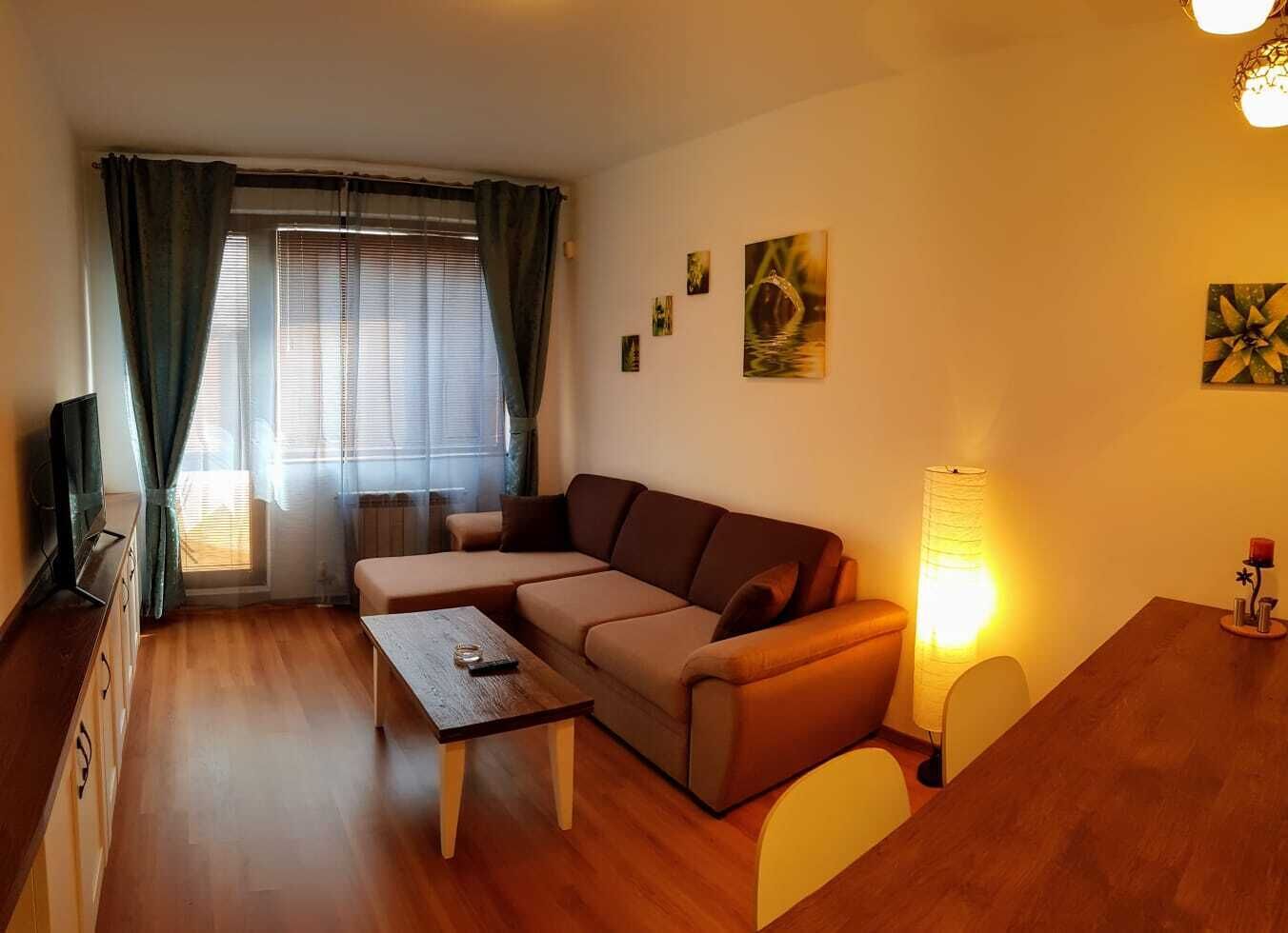Un salon confortable avec un canapé, une table basse et un téléviseur posé sur un meuble.