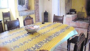 Comedor con una mesa grande, sillas y un muro decorativo con arcos.