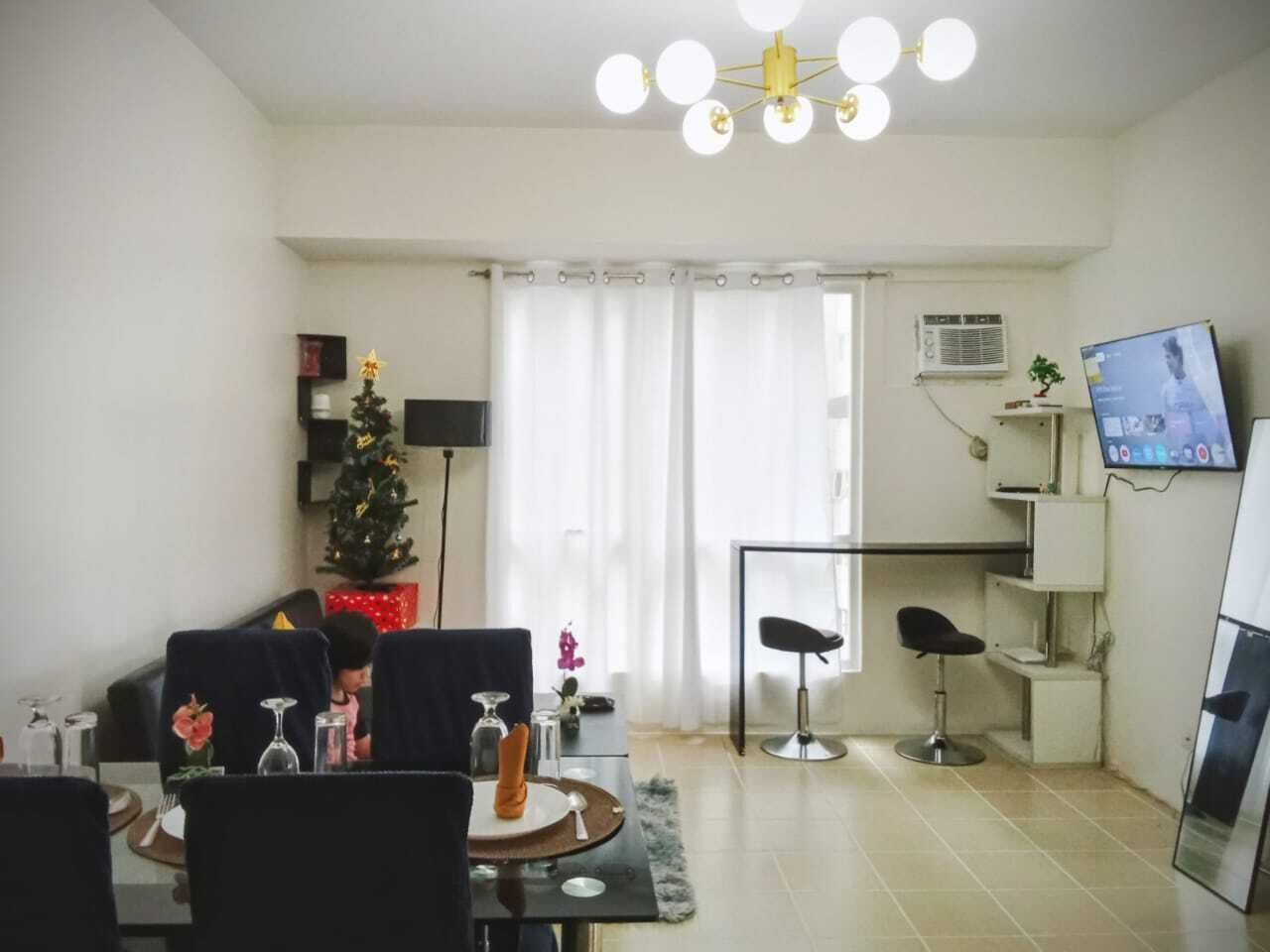 Un salon moderne comprenant un coin repas, un téléviseur et un sapin de Noël.