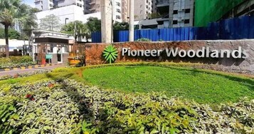 Pioneer Woodlands, con jardín ajardinado y entrada a un edificio.