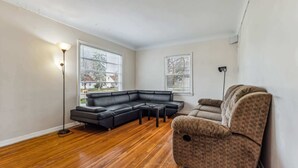 A living room with a sectional sofa, a patterned armchair, a small table, and two floor lamps.