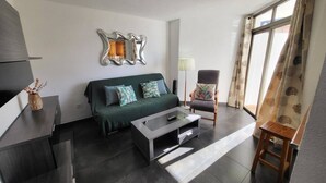 Ein modernes Wohnzimmer mit einer Couch, einem Sessel, einem Couchtisch und einer Lampe.