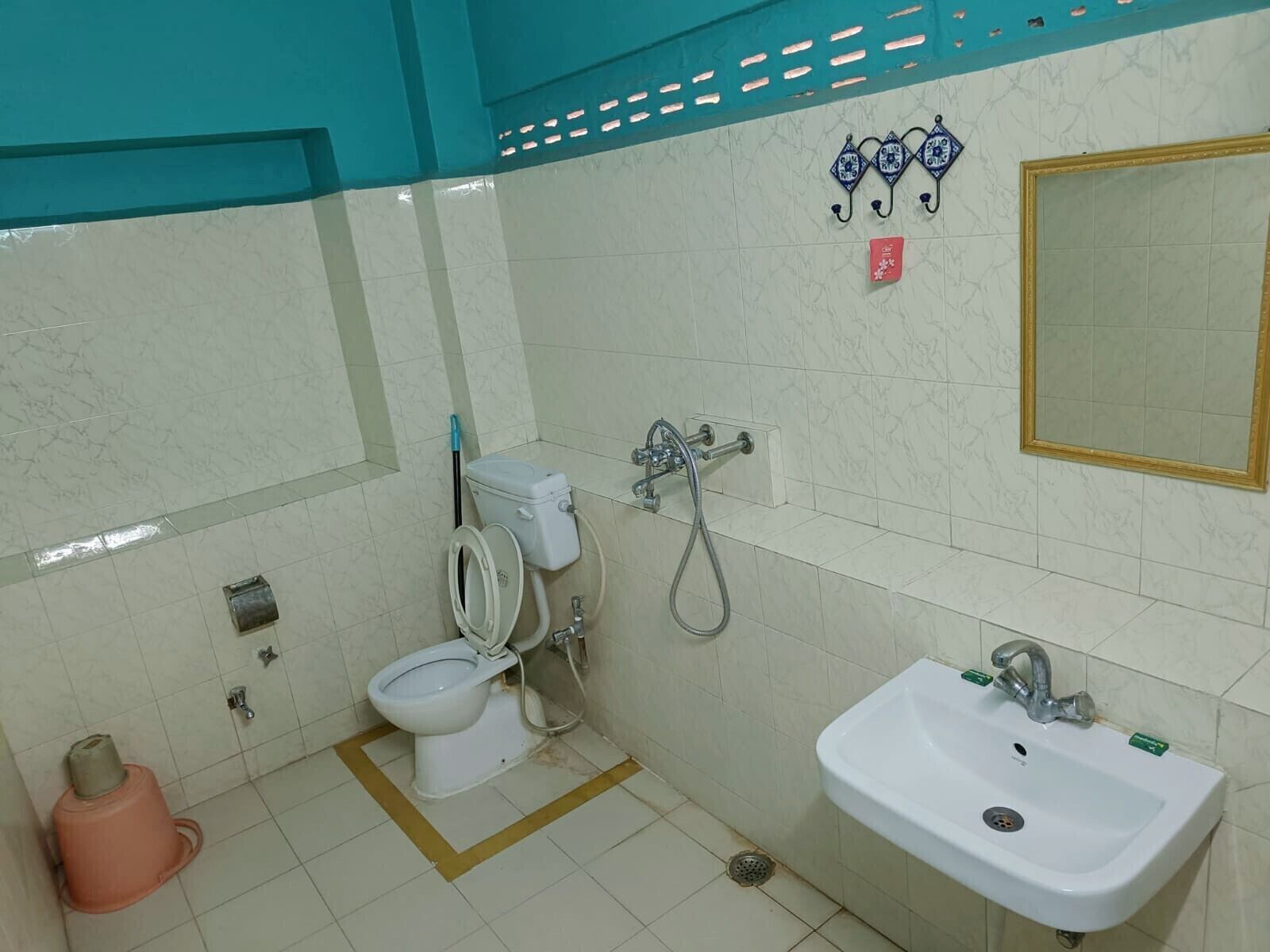 A bathroom with a toilet, bidet, sink, and a mirror.