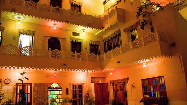A multi-level building with balconies, potted plants, and a traditional design. - Durag Niwas (Jodhpur)