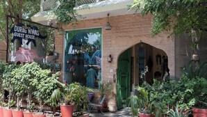 A guest house with a signboard, a green door, and potted plants. - Durag Niwas (Jodhpur)