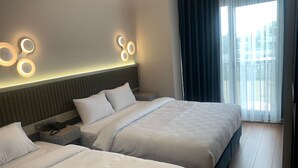 A hotel room with two beds, a modern headboard, and a large window with curtains. - Theodosius Hotel (Istanbul)
