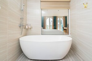 Deluxe kamer, balkon | Badkamer | Een bad/douchecombinatie, een haardroger, pantoffels, handdoeken