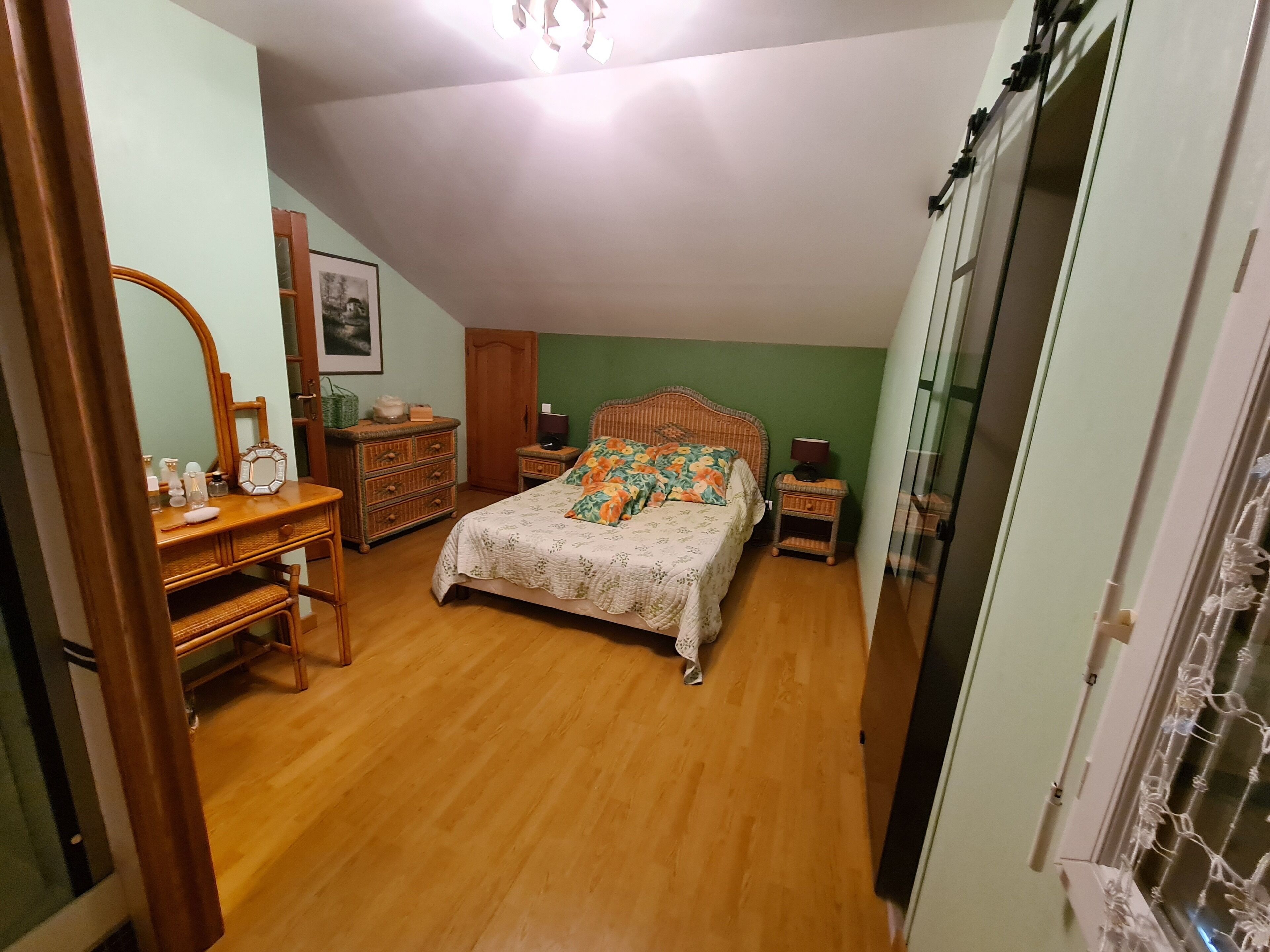 A bedroom with a bed, a dresser, a mirror, and a nightstand.