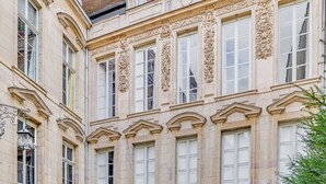 A classical building facade with ornate window frames and decorative moldings. - In the heart of town exceptional apartment nestled in an hôtel particulier. (Dijon)