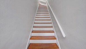 A staircase with white walls and wooden steps.