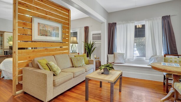 A living room with a sofa, a coffee table, and a window with curtains.