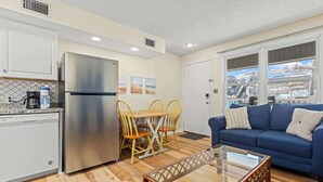 Un espace de vie compact comprenant une kitchenette, un coin repas et un canapé.
