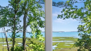 A view through a window of a natural landscape with trees and a body of water. - Assateague Holiday House Nature & Luxury Combined (Berlin)