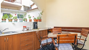 Una cocina compacta con armarios de madera, un banco empotrado y plantas en macetas.