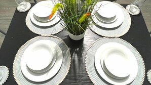 A table set with white plates and a decorative plant in the center. - Chantry Suites by SA Stays (Grimsby)