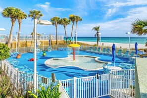 Ein Poolbereich mit blauem Wasser, Palmen und Blick auf den Strand.