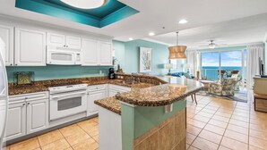 A modern kitchen with white cabinets, a granite countertop, and a large island.