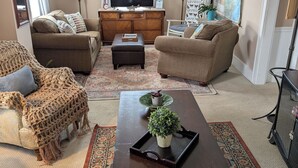 A cozy living room with two sofas, a coffee table, a TV, and decorative items. - Cozy home in Damascus located next to River, Trails, Bike Shops, and Dining. (Damascus)