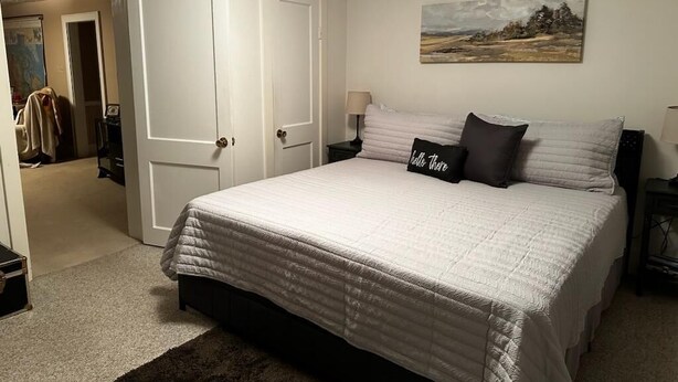 A bedroom with a large bed, a painting on the wall, and a door leading to another room. - Cozy home in Damascus located next to River, Trails, Bike Shops, and Dining. (Damascus)