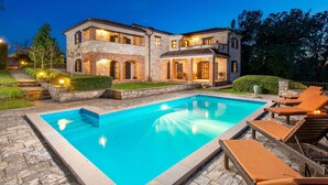 A large house with a swimming pool and outdoor seating.