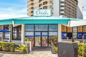 A restaurant named 'Oceans bar & grill' with a view of the ocean through the entrance. - Beautiful Fully Renovated Condo (Panama City Beach)