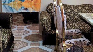 A room with patterned sofas, a chair, and a decorative curtain. - Immaculate 1-bed Apartment in Kingston 14 (Kingston)