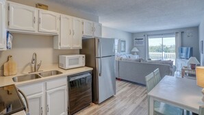 A modern kitchen with white cabinets, stainless steel appliances, and a wooden countertop. - Bayview Condo right on Lewes Beach (Lewes)