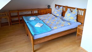 A bedroom with a wooden bed, a wooden desk, and a chair. - Geräumige Ferienwohnung "dresdner Stadt-terrasse" für 5 Erw., Kinder Willkommen (Dresden)