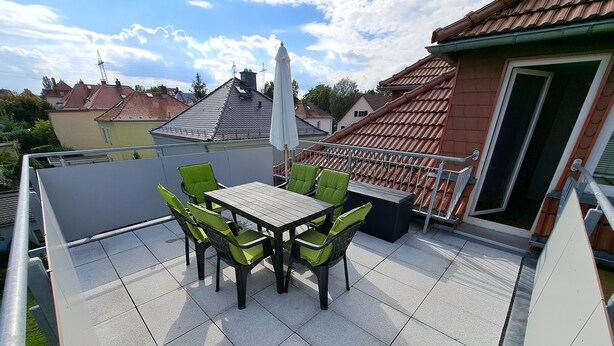 A rooftop terrace with a table and chairs, a white umbrella, and a view of neighboring houses. - Geräumige Ferienwohnung "dresdner Stadt-terrasse" für 5 Erw., Kinder Willkommen (Dresden)