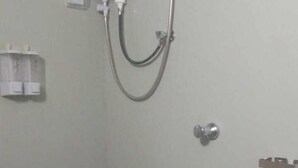 Ducha con cabezal de ducha manual y ventilador de pared.