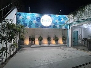 A modern building entrance with a 'hello' sign, potted plants, and a glass door. - Hello Airport Hotel Katunayake (Seeduwa - Katunayake)