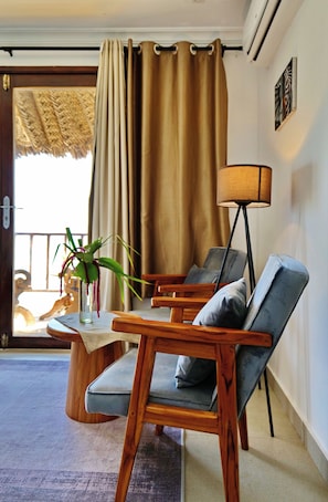 Ein Zimmer mit einem Holzbett, einem Tisch mit Blumenvase und einer Stehlampe.