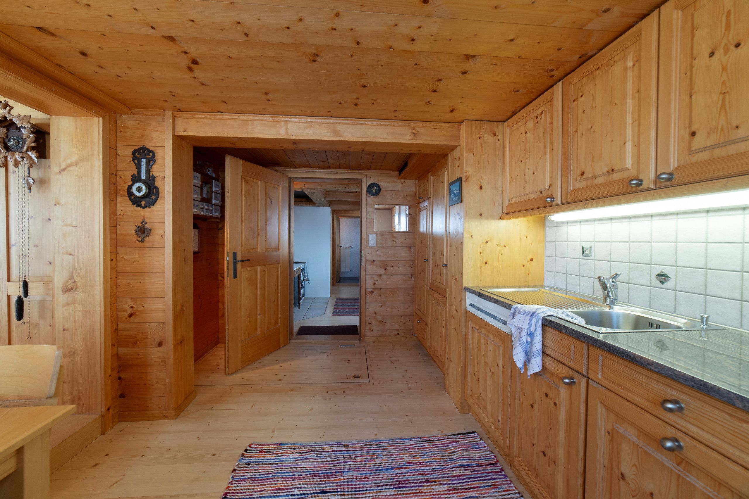 Un intérieur en bois comprenant un espace cuisine avec des placards, un évier et une fenêtre.